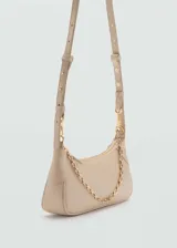 Bolso tipo baguette color beige, con asa corta de cadena dorada y cierre de cremallera superior.