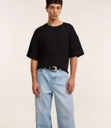 Pantalón de jeans celeste con textura, corte super baggy, cintura con trabillas, cierre tradicional y bolsillos.