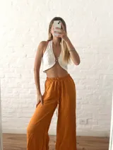 Pantalón palazzo color naranja, de tiro alto con cintura elastizada y cordón ajustable.