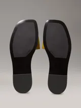 Ojotas amarillas de lona con logo de Calvin Klein grabado en la tira.