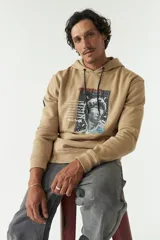 Canguro azul marino de felpa con capucha y cordones blancos. Presenta un estampado con una imagen de una escultura y texto en verde y blanco. Tiene bolsillos tipo canguro y puños y cintura acanalados.