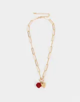 Set de tres collares dorados con diferentes cadenas de eslabones y dijes metálicos: cadena gruesa con cierre de barra, cadena con eslabones rectangulares y dije de rosa roja, y cadena con dije de moño.