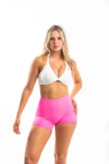 Top deportivo blanco con breteles finos y diseño cruzado en el frente.