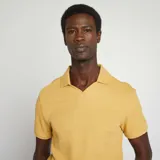 Remera amarilla de punto de piqué con cuello polo y mangas cortas.