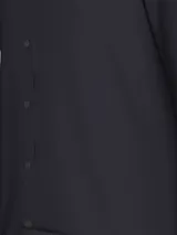 Camisa de vestir azul marino, corte slim, con cuello abotonado, cierre con botones y mangas largas. Presenta un mini monograma bordado en el pecho y logo de Calvin Klein Jeans en la parte inferior.