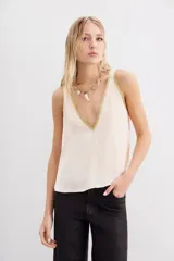 Top negro de viscosa con escote en V y detalle de lurex dorado en los bordes.