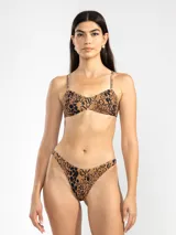 Conjunto de bikini color marrón con estampado de manchas negras. El corpiño es de breteles finos y se ata en la espalda. La bombacha es de tiro alto y cobertura mínima.