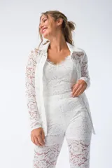 Camisa blanca de encaje con cuello camisero y cierre frontal con botones.