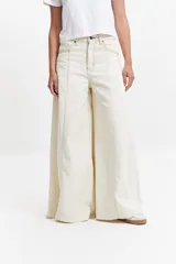 Pantalón jean oxford de tiro alto color crudo, de corte ajustado en la cadera y amplio desde la rodilla.