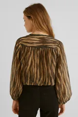 Blusa de poliéster con estampado abstracto en tonos beige y negro, escote en V con frunce, mangas largas abullonadas con puños elásticos y corte a la cintura con elástico.