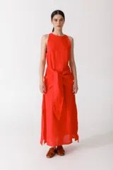 Vestido largo color rojo, sin mangas, con cuello redondo y lazo a la cintura.