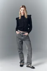 Pantalón de jean de tiro alto, denim negro rígido con lavado gris localizado, bigotes y apliques laterales.