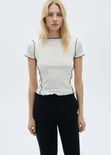 Camiseta blanca de algodón con cuello redondo y mangas cortas con borde negro.