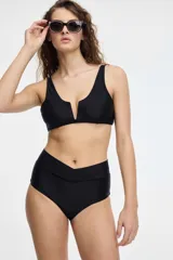 Conjunto de bikini negro con corpiño de escote en V y bombacha tiro alto con detalle en V en la cintura.