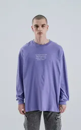 Remera lila de algodón con corte oversize, mangas largas y estampa frontal con la frase "La vida es como una caja de bombones, nunca sabes lo que te va a tocar".