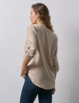 Blusa color beige de poliéster con escote en V y mangas 3/4 regulables con presilla y botón.