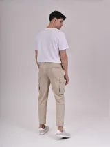 Pantalón cargo color beige, de corte recto y tiro medio, con bolsillos laterales con solapa y bolsillos delanteros y traseros.