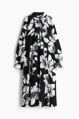 Vestido camisero midi de viscosa con estampado floral en blanco y negro, cuello camisero, tapeta de botones oculta, mangas raglán largas con puños sencillos y costuras fruncidas en la pollera.