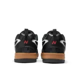 Championes urbanos New Balance modelo 808, color negro con detalles en blanco y suela marrón.