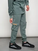 Pantalón de jogging gris con bolsillos cargo laterales y logo de la marca bordado en la pierna.