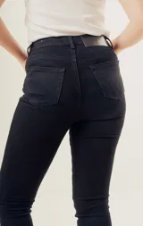 Pantalón de jean negro de corte recto, tiro alto y cinco bolsillos.