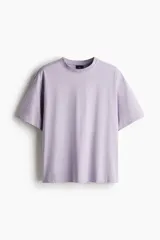 Remera lila de algodón pesado, corte holgado, con cuello redondo ribeteado y hombros caídos.