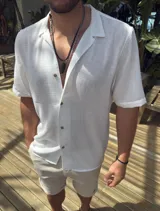Camisa blanca de fibrana de manga corta con cuello clásico y cierre con botones.