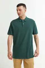 Remera tipo polo de piqué color verde oscuro, con cuello clásico y tapeta de dos botones.