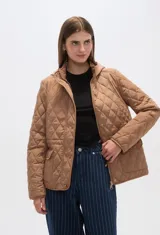 Campera blanca con diseño acolchado, cierre frontal con botones a presión y capucha desmontable.