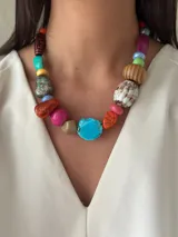 Collar corto con cuentas de cerámica, acrílico y piedras de diferentes colores y formas. Cierre con cadena de acero quirúrgico y gancho regulable.