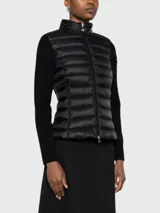 Cardigan negro con frente acolchado y cierre de cremallera, cuello alto, mangas largas de lana virgen y logo en la manga.