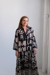 Vestido largo negro con estampado floral en tonos beige, corte amplio, cuello mao y mangas 3/4 acampanadas.