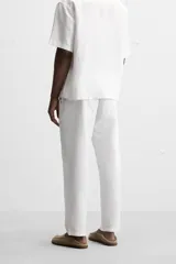 Pantalón azul marino de corte amplio, confeccionado en tejido de mezcla de algodón y lino. Cuenta con cintura elástica ajustable con cordón, bolsillos frontales y bolsillos traseros de vivo.