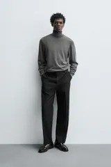 Jersey negro de punto fino con cuello alto y manga larga.