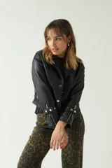 Campera tipo cuero color beige, ajustada al cuerpo y de longitud a la cintura, con cierre de botones y bolsillos.