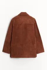 Blazer de cuero color marrón, con cuello solapa de muescas y manga larga. Tiene bolsillos con solapa en delantero, forro interior y cierre frontal con botones.