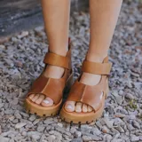 Sandalias de cuero color marrón claro, con puntera descubierta, tira ancha sobre el empeine, talonera cerrada y suela track.