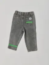 Pantalón de jean celeste con efecto lavado, corte recto y largo a la rodilla. Presenta una cinta vertical color violeta en la pierna izquierda, una cinta vertical color verde en la pierna derecha y una cinta horizontal color rosa en la parte inferior de ambas piernas.