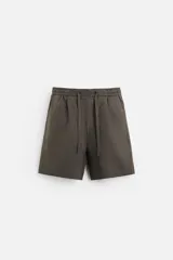 Bermuda regular fit negra confeccionada en tejido de lino. Cintura elástica ajustable con cordón y pliegues frontales. Bolsillos frontales y detalle de bolsillos traseros de plastrón.