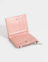 Billetera pequeña color rosa con textura acolchada y pespuntes verticales. Tiene cierre superior y broche con botón para cerrar.