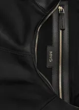 Bolso tipo hobo de cuero negro con asa rígida de metal dorado.