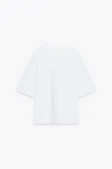 Camiseta blanca de algodón, corte boxy fit, cuello redondo, manga corta y etiqueta contrastante en la espalda.