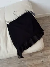 Minifalda negra con cintura elástica y volados de tul en el ruedo.