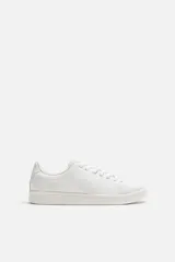 Zapatillas urbanas de cuero liso color blanco, con cordones y suela plana.