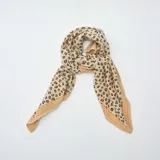 Pañuelo cuadrado de tela color beige con estampado de manchas de leopardo en marrón y negro.