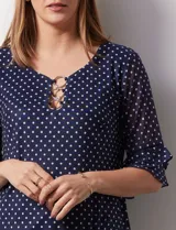 Blusa Harper de microtul estampado azul con lunares blancos, cuello redondo, escote en U con aplique de aros y mangas cortas amplias.