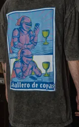 Remera gris de manga corta con cuello redondo y calce oversize. Estampa en sublimación con diseño de un caballero medieval tomando vino y usando un celular. Confeccionada en 100% algodón premium.