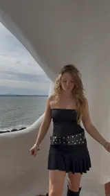 Vestido corto negro sin mangas, confeccionado en jersey de lycra con delantera doble.