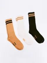 Pack de tres pares de medias de caña corta, una color camel con dos rayas horizontales negras en la parte superior, otra blanca con dos rayas horizontales color camel en la parte superior y otra verde oscuro con dos rayas horizontales color camel en la parte superior.