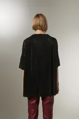 Blusa negra con cuello en V y mangas cortas, de tejido plisado.